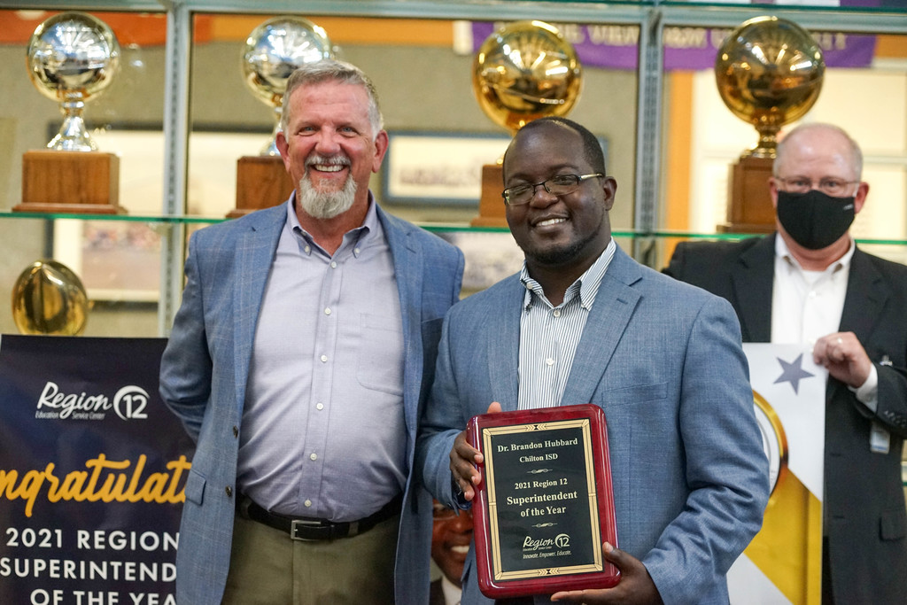 Superintendent Dr. Brandon Hubbard being presented with the Region 12 Superintendent of The Year Award by Region 12 Executive Director Dr. Jerry Maze